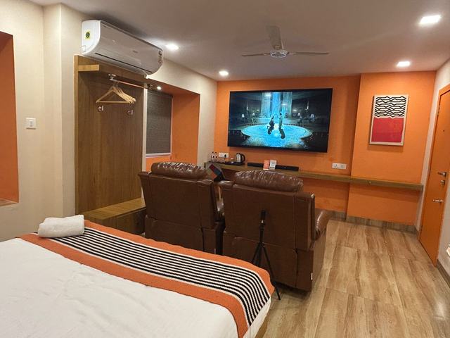 Theatre room with recliners, bed and wall-mounted screen