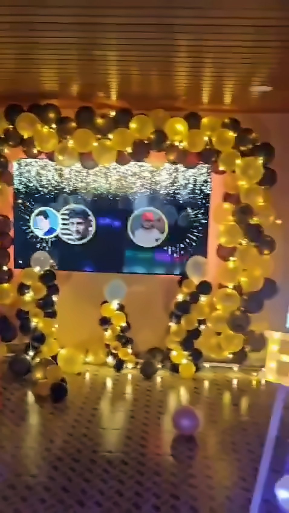 Balloon arch around the big screen with a birthday welcome