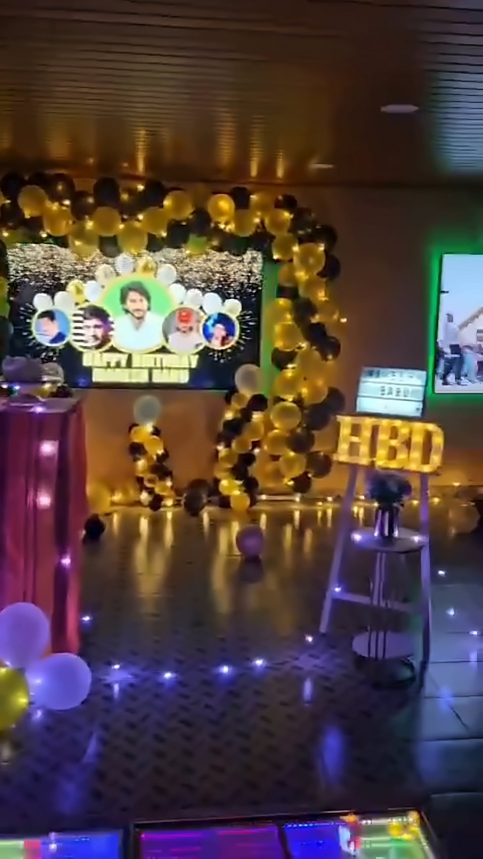 Birthday balloon arch and lit cake table in the party hall